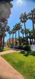 eine Reihe von Palmen in einem Park mit Bürgersteig in der Unterkunft Costa Caribe II Nº 1028 in Oropesa del Mar