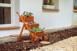 a wooden cart with three plants in it at Apartmány Lenkoska in Nový Přerov