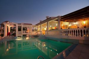 a house with a swimming pool at night at Hotel Caretta Beach in Gerani
