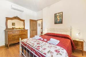 a bedroom with a bed with a red bedspread and a mirror at Borgo Panicale with Shared Pool and Garden in Panicale +54 photos