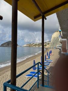 a row of blue chairs on a beach at Hotel Angelino in Ischia