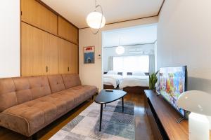 ein Wohnzimmer mit einer Couch und einem Bett in der Unterkunft Animal Art Apartment Type 12 in Tokio