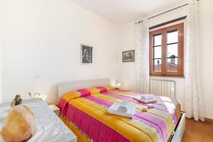 a bedroom with a bed with a colorful blanket at Borgo Panicale with Shared Pool and Garden in Panicale