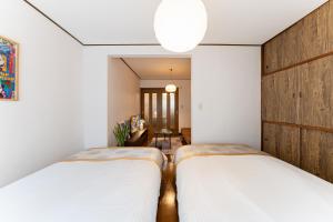 zwei Betten in einem Zimmer mit weißen Wänden in der Unterkunft Animal Art Apartment Type 12 in Tokio