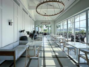 a restaurant with tables and chairs and a chandelier at DCAO Villas Novaworld Phan Thiet in Bình Tú