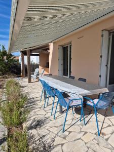 a picnic table and chairs on a patio at Maison familiale entre mer et foret 6 pers - Clim in Saint-Trojan-les-Bains