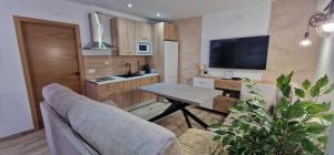 a living room with a table and a kitchen at CAZORLA NATURA - NUEVOS 2025 - 6 Apartamentos Turísticos- in Arroyo Frio