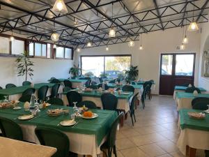 a dining room with green tables and chairs at Hotel Miramare Garzia in Marinella di Selinunte