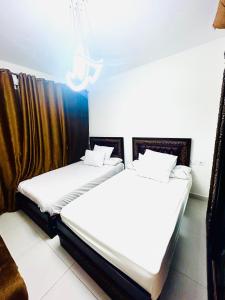 two beds in a room next to each other at Chalet at Marassi, Marina West in El Alamein