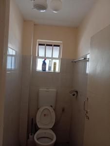 ナイロビにあるBloom suitesのトイレと窓のあるバスルーム