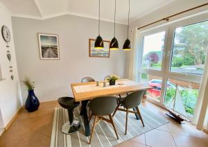 a dining room with a wooden table and chairs at Birkennest in Zingst