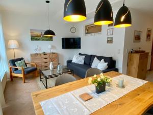 a living room with a blue couch and a table at Birkennest in Zingst