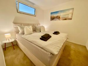 a white bed in a room with a window at Birkennest in Zingst