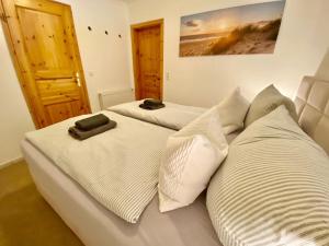 a bedroom with two beds with white pillows at Birkennest in Zingst +4 photos