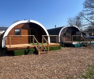 a couple of yurt houses with a bench and a porch at The Bell Inn in Wendens Ambo