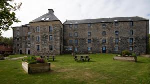 een groot bakstenen gebouw met picknicktafels ervoor bij Budle Bay Loft in Bamburgh