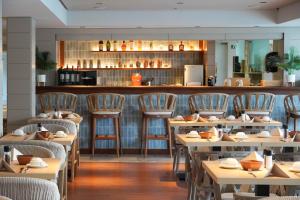restauracja z drewnianymi stołami i krzesłami oraz barem w obiekcie Marins Suites - Adults Only Hotel w Cala Millor +37 zdjęć