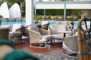 szereg krzeseł i stołów obok basenu w obiekcie Marins Suites - Adults Only Hotel w Cala Millor