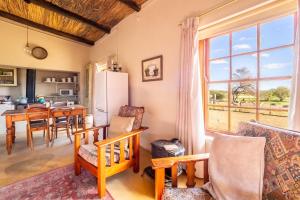 a kitchen and living room with a table and a refrigerator at Skooltjie Cottage in the Tankwa Karoo in Sutherland