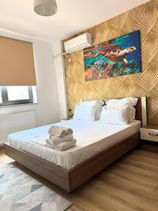 a bedroom with a bed with a painting on the wall at Lira Holiday Apartments in Eforie Nord