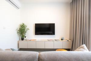 a living room with a tv on a white cabinet at Luxury Apartment Valley Views A8 in Xagħra