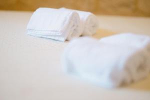 a stack of white towels on a bed at TRULLO MALVISCHI - Privacy & Pool in Alberobello +43 photos