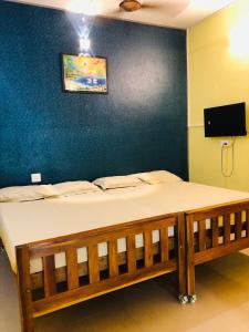 a bed in a room with a blue wall at Morning Star Homestay- Malpe Beach in Malpe