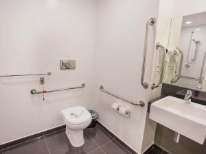 ein Badezimmer mit Toilette und Waschbecken in der Unterkunft ibis Styles Taubate in Taubaté + 37 Fotos
