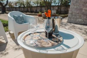 a table with two glasses and a bottle of wine at TRULLO MALVISCHI - Privacy & Pool in Alberobello