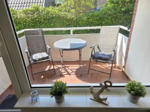 un balcón con 2 sillas y una mesa en el patio en FeWo Büsum No 12, en Büsum