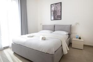 een slaapkamer met een groot bed met witte lakens bij Luxury Apartment Valley Views B12 in Xagħra +15 foto's