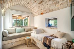 un salon avec un canapé et une fenêtre dans l'établissement Trulli cicale e olive - Le Case di Valentina, à Ceglie Messapica 52 autres photos