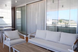 a living room with a white couch and a chair at T3 Baía de São Martinho in São Martinho do Porto