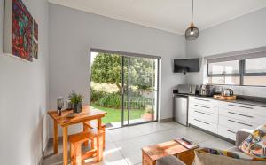a living room with a table and a kitchen at The Art Barn in Stilbaai
