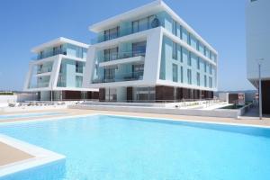a building with a swimming pool in front of a building at T3 Baía de São Martinho in São Martinho do Porto
