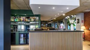 a bar in a restaurant with a lot of drinks at Campanile PRIME - Nîmes Centre in Nîmes
