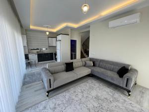 a living room with a couch and a kitchen at Soğucak Villa in Kuşadası