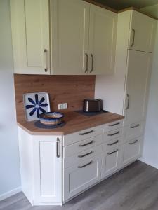 a kitchen with white cabinets and a counter top at Naturblick in Aukrug