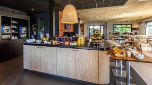 a restaurant with a counter with food on it at Campanile PRIME - Nîmes Centre in Nîmes