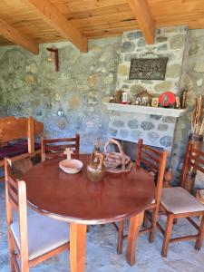 a dining room with a wooden table and chairs at Guesthouse Lika in Shkozë