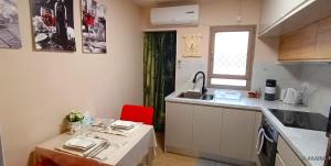 een kleine keuken met een tafel en een wastafel bij Sweet Home in Dimona +14 foto's