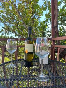 a bottle of wine and two wine glasses on a table at Villa H&M in Baška Voda +35 photos