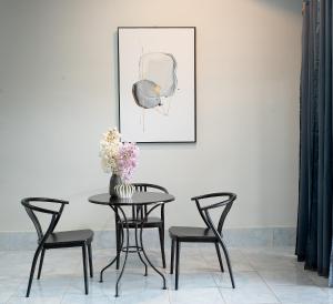 a dining room table with chairs and a vase with flowers at satun muslimhome in Ban Khlong Kua