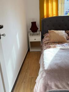 a bedroom with a bed and a lamp on a wooden floor at Goździkowy Apartament in Frombork