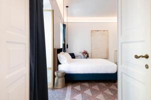 a bedroom with a white bed and a window at RELSTAY - Assarotti Suites in Genoa