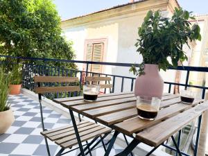 una mesa de madera con 2 copas de vino en el balcón en Central and Fully-Equipped, en Kavala