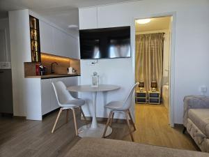 a kitchen and a living room with a table and chairs at Mala kuća Divna in Brela