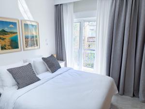 Una habitación blanca con una cama y una ventana en Central and Fully-Equipped, en Kavala