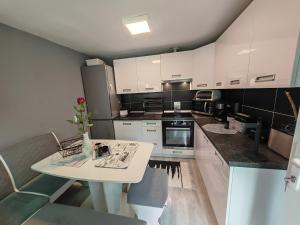 a kitchen with white cabinets and a white table at Miklós Lak in Miercurea-Ciuc
