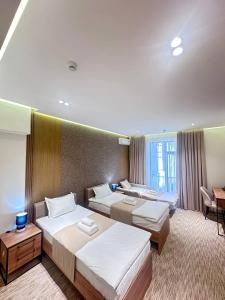 a hotel room with two beds and a desk at North Star Hotel in Yakkasaray